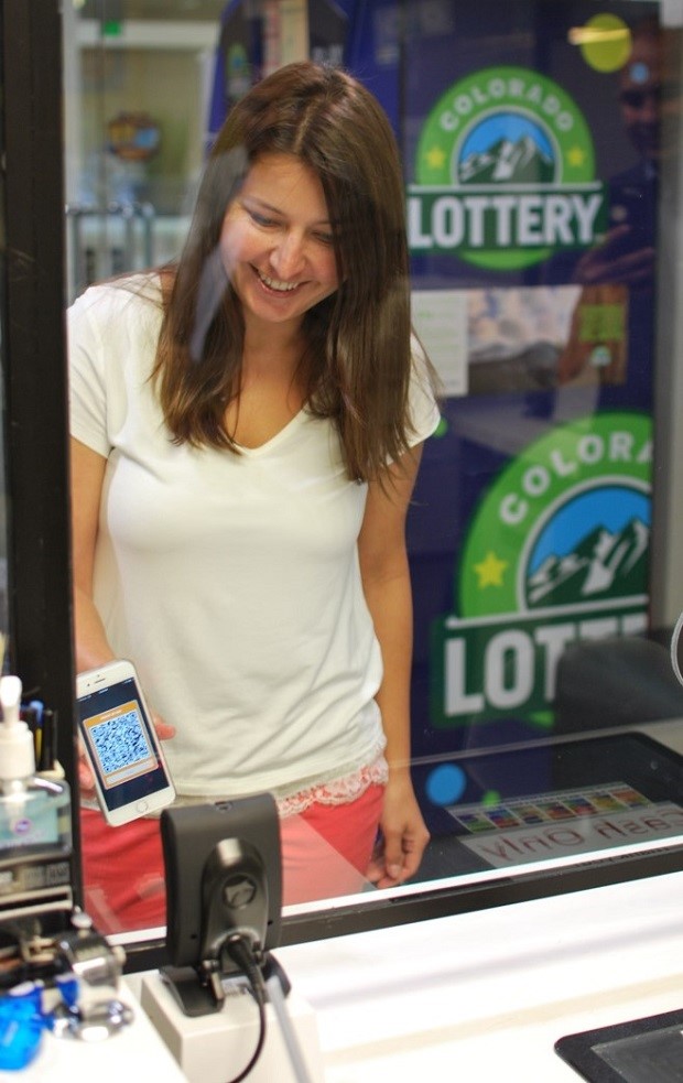At the lottery claims center, a pilot participant scans her DDL to purchase a lottery ticket.